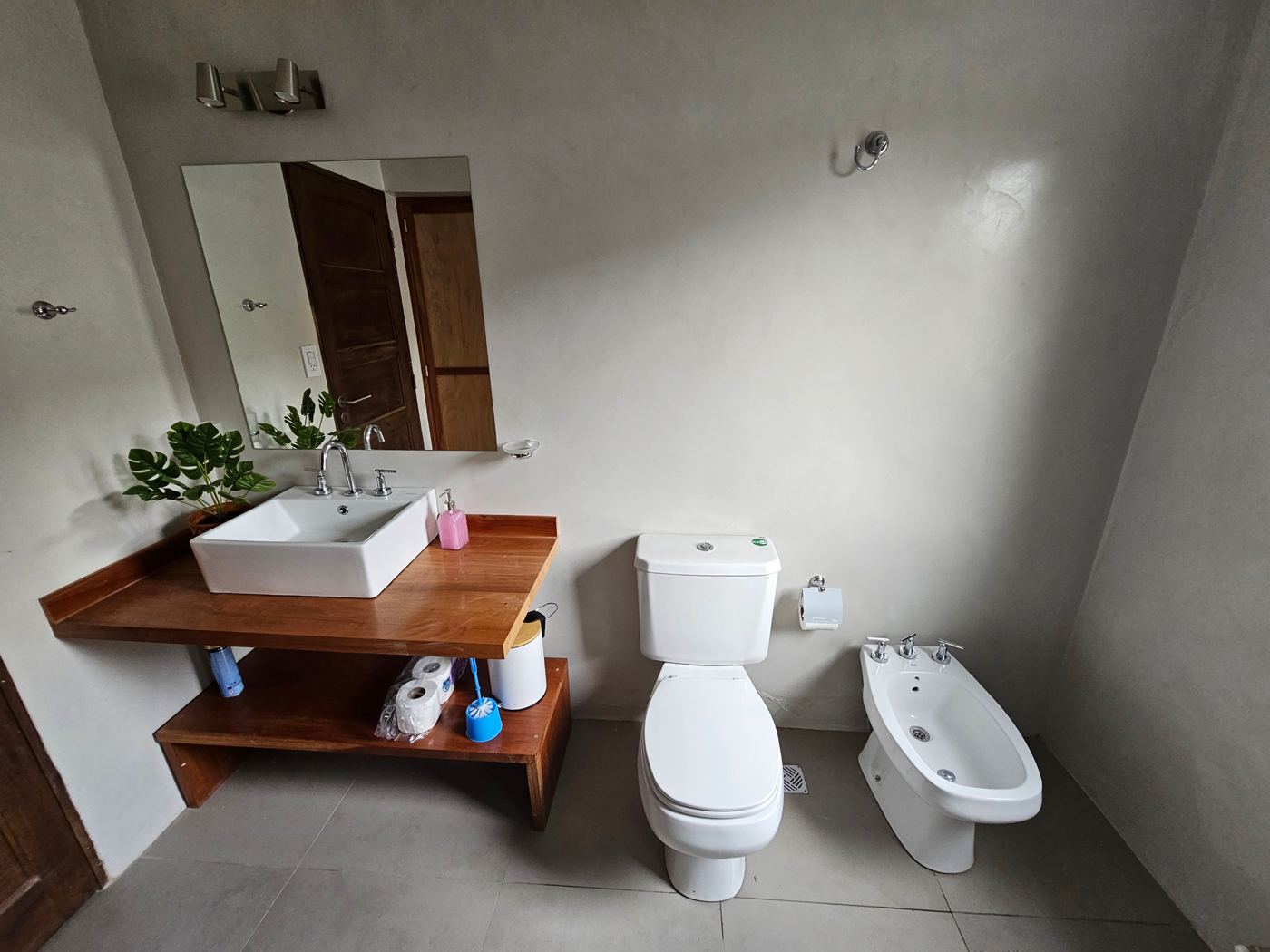 Baño con bacha de apoyo sobre mesada de madera